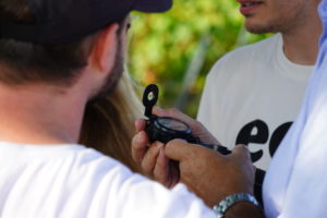 Equipe qui regarde la boussole pour réussir Escape Game